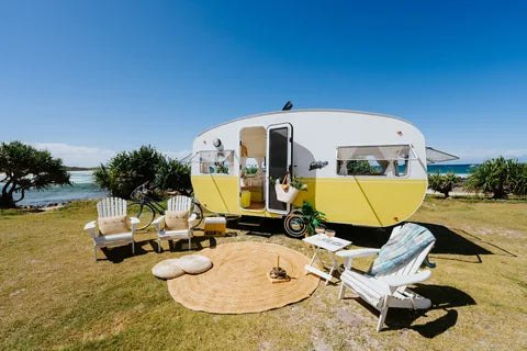 Caravan and outdoor seating beside the water